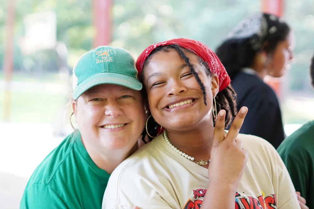counselor and camper making a peace sign